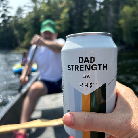Can of Dad Strength IPA being enjoyed in a canoe on the lake.