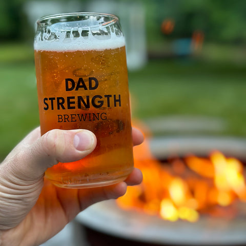 Dad Strength IPA in branded glass in a backyard