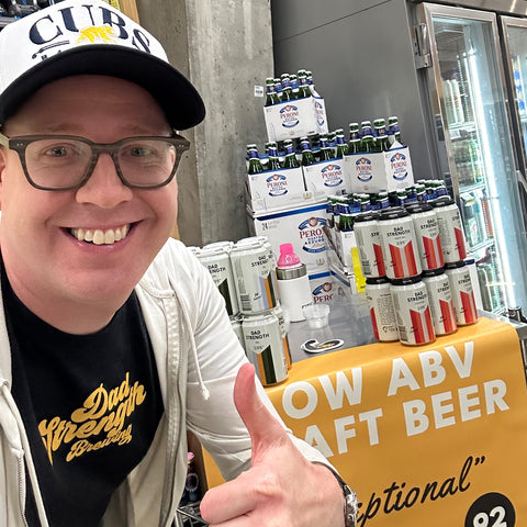 Dad Strength Brewing Field Team member giving a thumbs-up at a retail beer tasting display featuring Dad Strength low-ABV craft beer.